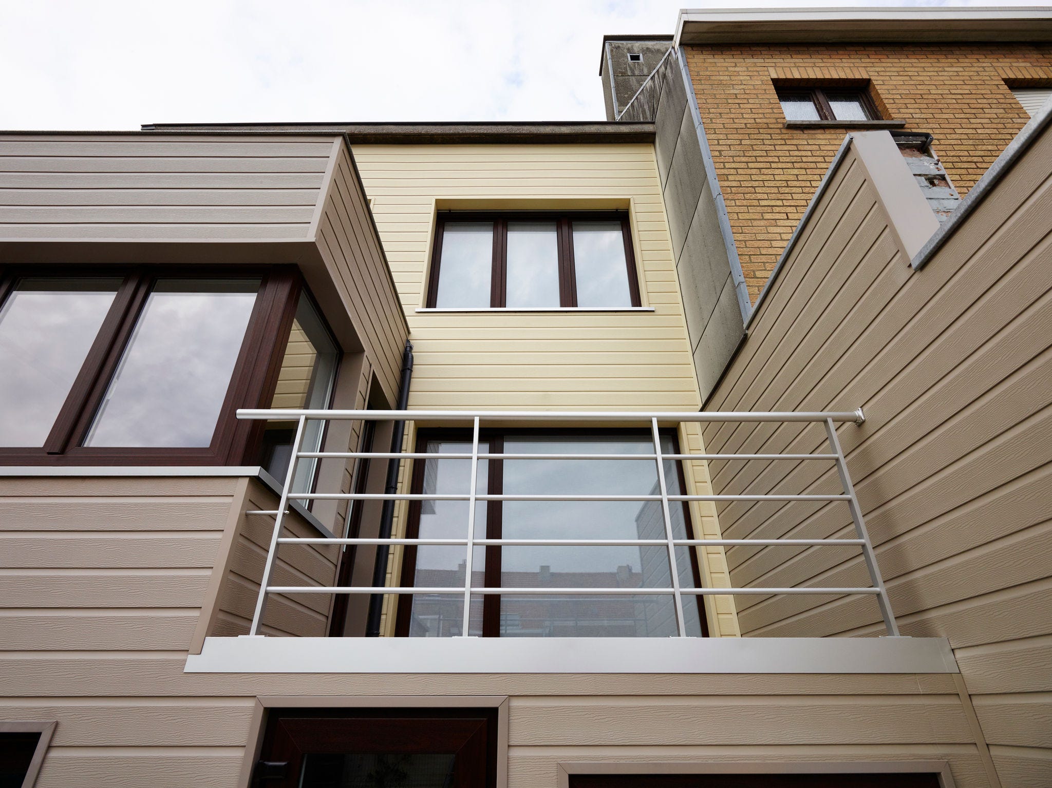 Moderne Fassadengestaltung eines Reihenhauses mit Deceuninck Solid Pure Fassadenverkleidung und Balkon