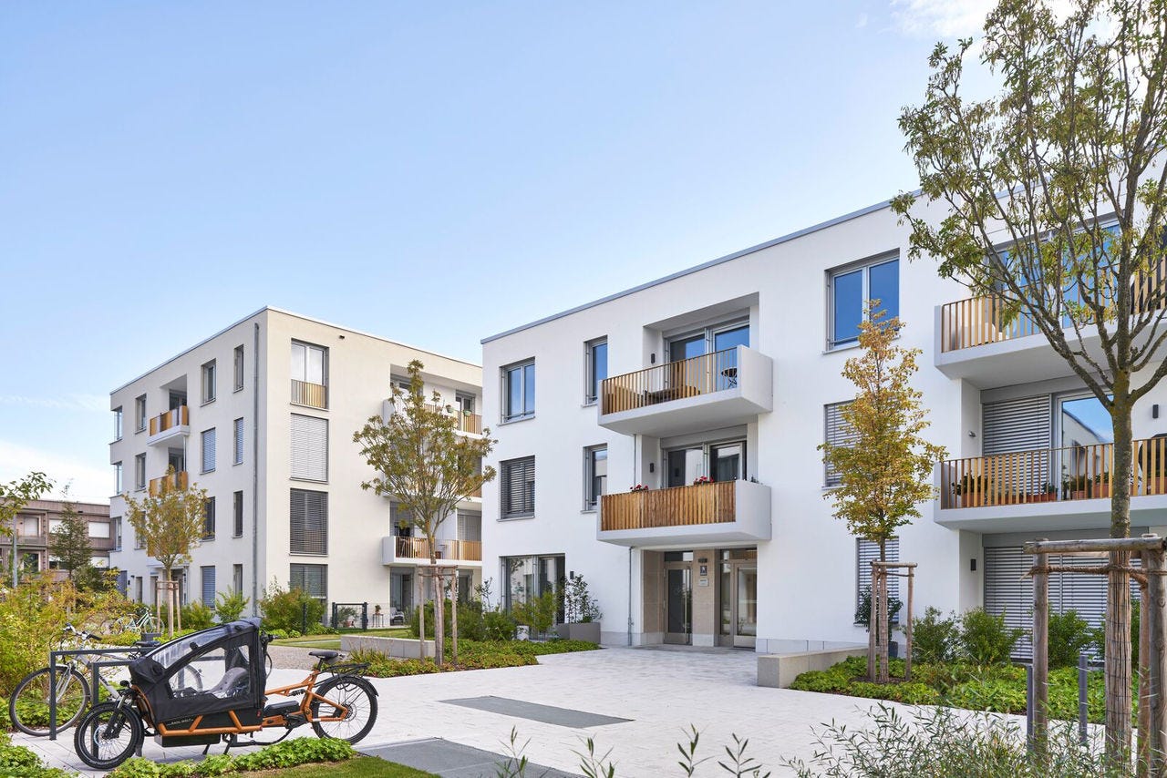 Moderne Architektur mit Deceuninck Kunststofffenstern an einer weißen Wohngebäude-Fassade